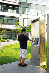 Image showing asia boy play the touch screen in modern building outside 