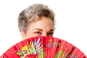 Image showing Senior woman with red dragon fan