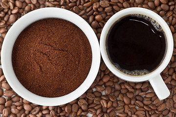 Image showing Coffee power in bowl and coffee in cup on top of coffee beans