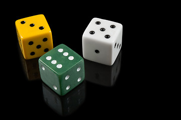 Image showing Green, yellow and white dices on black background