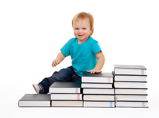 Image showing Happy kid sitting on the steps of books