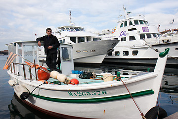 Image showing MARSEILLE, FRANCE,  MARCH 6: a fisherman,  standing in his boat,  in the Vieux-Port, on Sunday, March 6th, 2011 in Marseille, France.