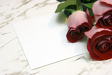 Image showing Three red roses and note