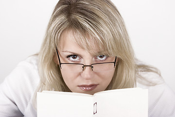 Image showing The girl hides behind the book