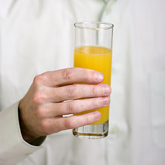 Image showing Glass with orange juice in a hand