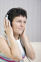 Image showing The girl listens to music in ear-phones