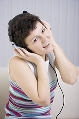 Image showing The girl listens to music in ear-phones