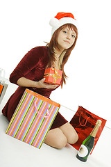 Image showing The girl in a Christmas cap with purchases