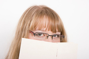 Image showing The girl hides behind the book