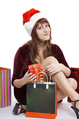 Image showing The girl in a Christmas cap with purchases