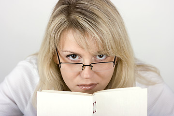 Image showing The girl hides behind the book