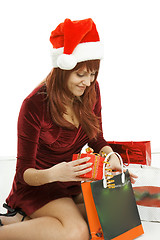 Image showing The girl in a Christmas cap with purchases