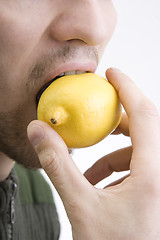 Image showing The man bites lemon