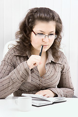 Image showing The puzzled girl with notebook and the handle