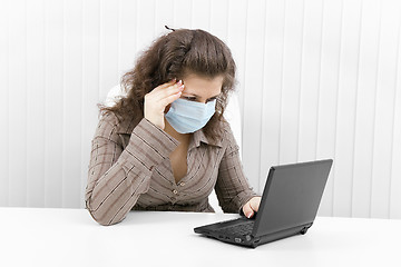 Image showing The young woman in medical mask with the laptop