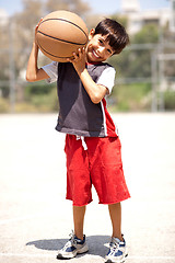 Image showing Boy with basketball on his shoulders