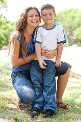 Image showing Image of Caring mother embracing her son while at the park