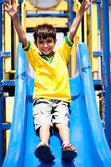 Image showing Young smart kid sliding down the swing
