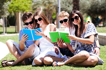 Image showing Young couples relaxing in park and reading books