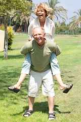 Image showing image of Senior man giving woman piggyback ride
