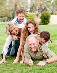 Image showing Family piling up on dad