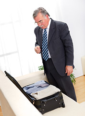 Image showing Man looking at suitcase