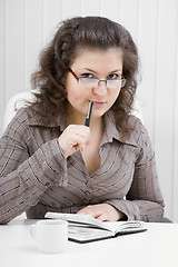 Image showing The puzzled girl with notebook and the handle