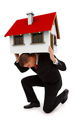 Image showing Business man holding house on his back