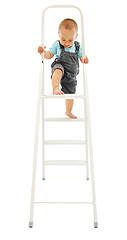 Image showing Little boy climbing up on ladder