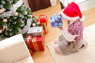 Image showing Girl in christmas, looking inside gift box