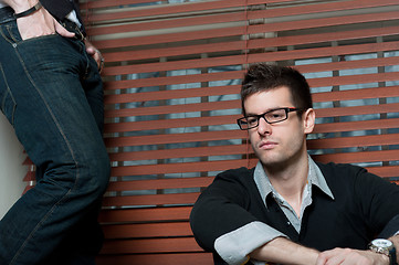 Image showing Young student with glasses sitting in window with man in jeans