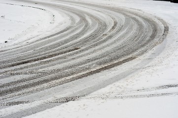 Image showing Curve in road covered by snow with track