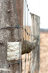 Image showing Wooden fence with metal plate against blurry background