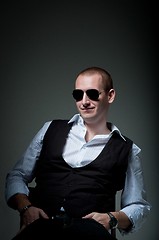 Image showing Young man sitting in chair smiling in sunglasses