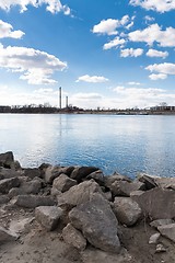 Image showing Bank of a river with powerplant and blue sky