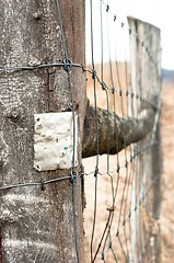 Image showing Wooden fence with metal plate against blurry background