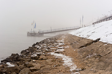 Image showing Dirty shore in the fog with jetty in the background