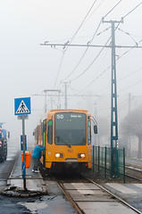 Image showing New tram with passanger getting on in the fog