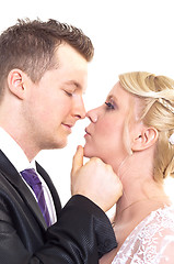 Image showing A couple on their wedding day kissing and laughing