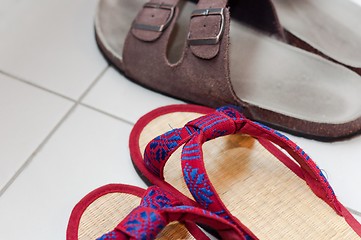 Image showing Closeup of vietnamese and european slippers on white floor