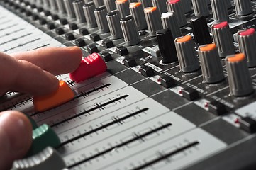 Image showing Part of an audio sound mixer with buttons and sliders and hand