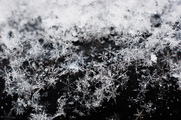 Image showing Ice cristals falling with black background macro shot