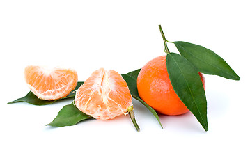 Image showing Whole and peeled mandarines and some mandarin leaves