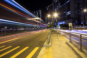 Image showing blurred bus light trails in downtown night-scape 