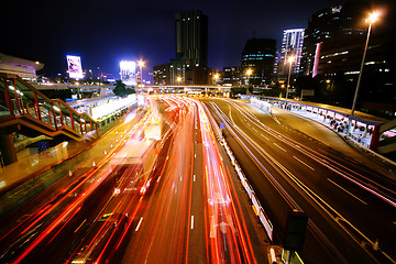 Image showing blurred bus light trails in downtown night-scape 