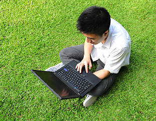 Image showing asian man using computer outdoor