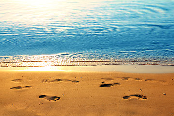 Image showing footprints on sand along sea at dawn