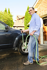 Image showing Man washing car on driveway