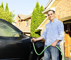 Image showing Man washing car on driveway