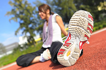 Image showing woman doing stretching exercise in sport field